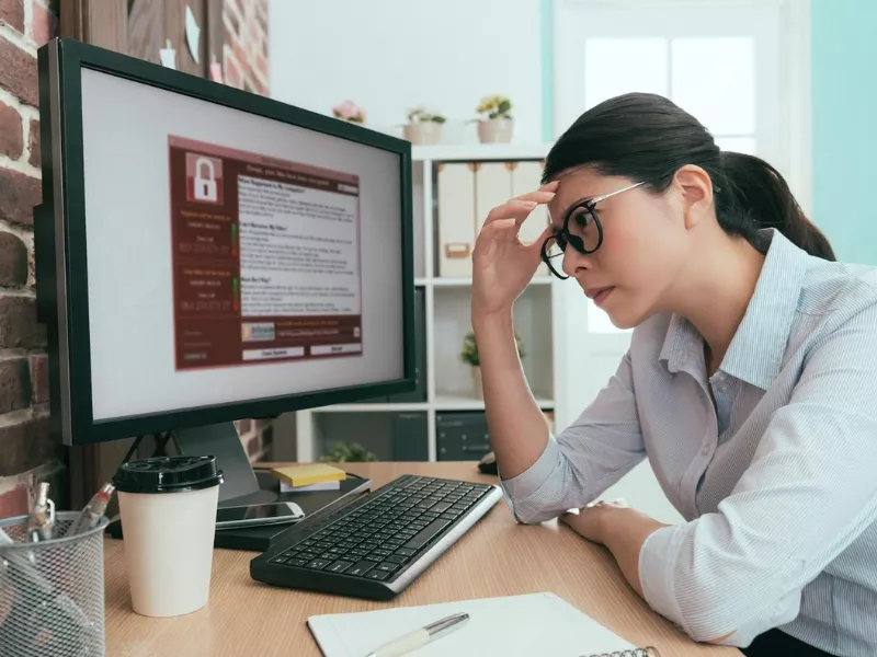 Woman looking at a computer screen, learning how to list qualifications on a CV.